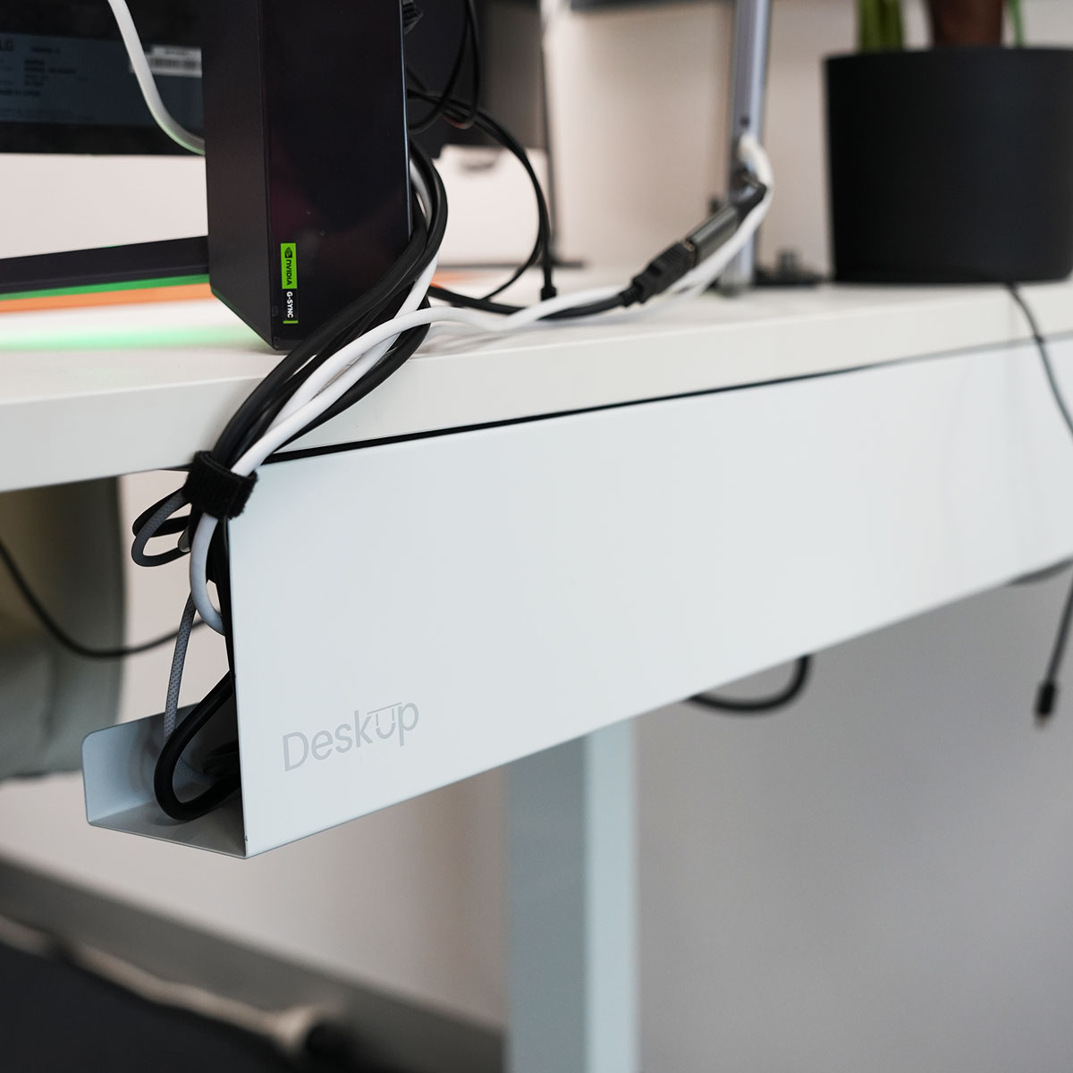 Mesh cable tray mounted under a sit-stand desk